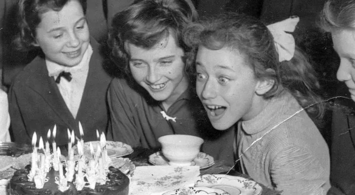 Черно-бяла снимка на семейство, празнуващо рожден ден на момиче с торта