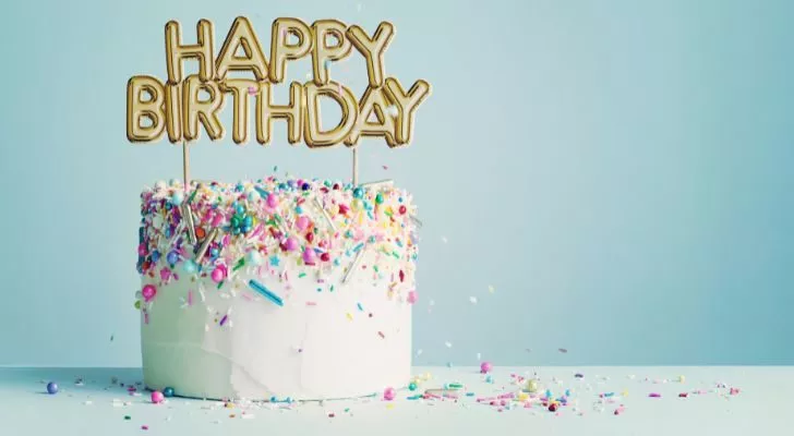 Модерна торта за рожден ден, покрита с бяла глазура и свещи отгоре