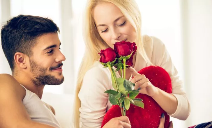 Мъж подарява рози на жена.