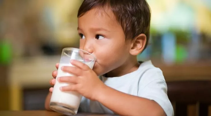 Момче пие чаша мляко
