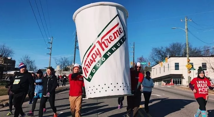 Участниците в Krispy Kreme Challenge носят огромна чаша.