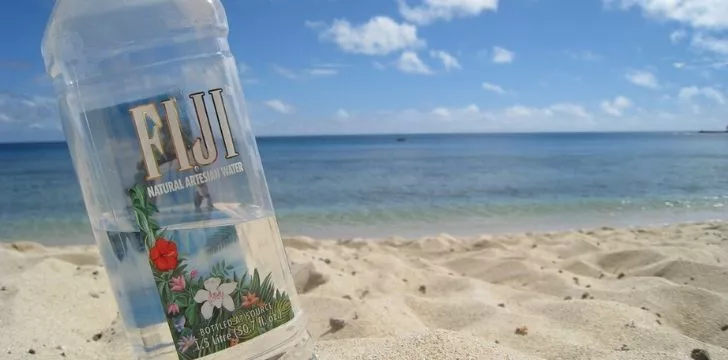 Бутилка вода Фиджи на плажа