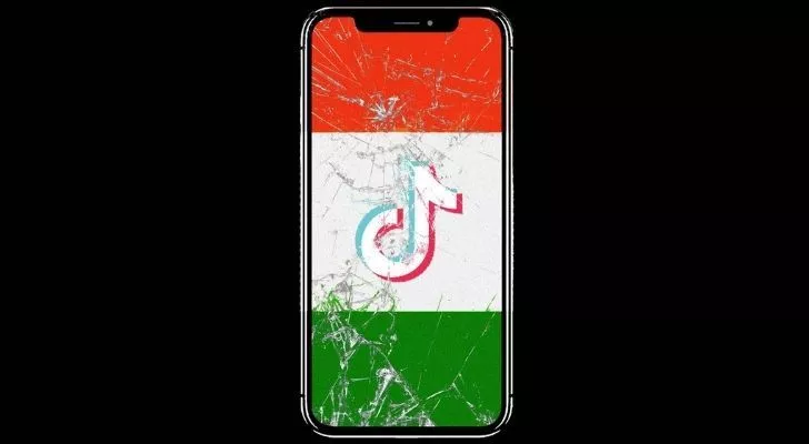 Разбит смарт телефон със знамето на Индия на екрана и логото на Tik Tok в средата