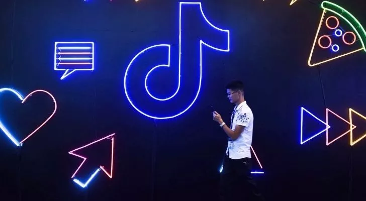 Някой използва Tik Tok на телефона си, докато върви