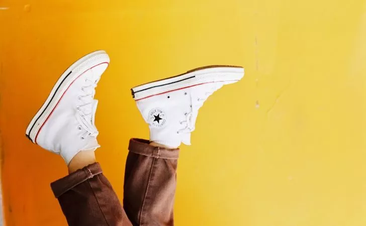 Човек, облечен в бяло Chuck Taylors