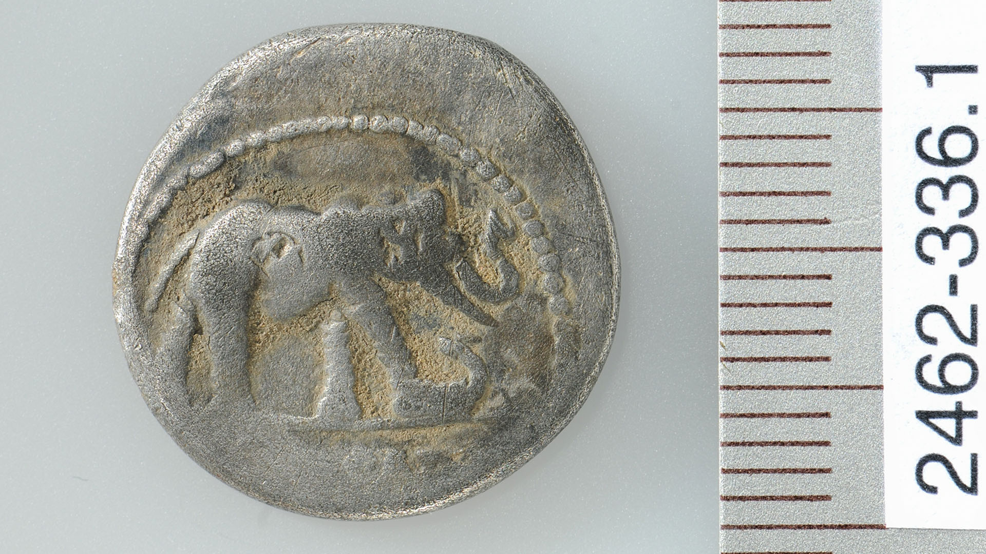 Сребърна монета, изобразяваща слон, тъпчещ змия или малък дракон
