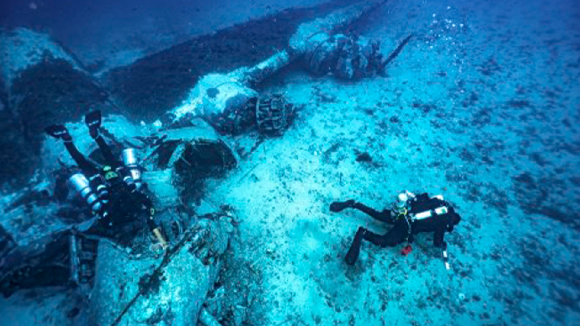 Двама водолази изследват останките под вода.
