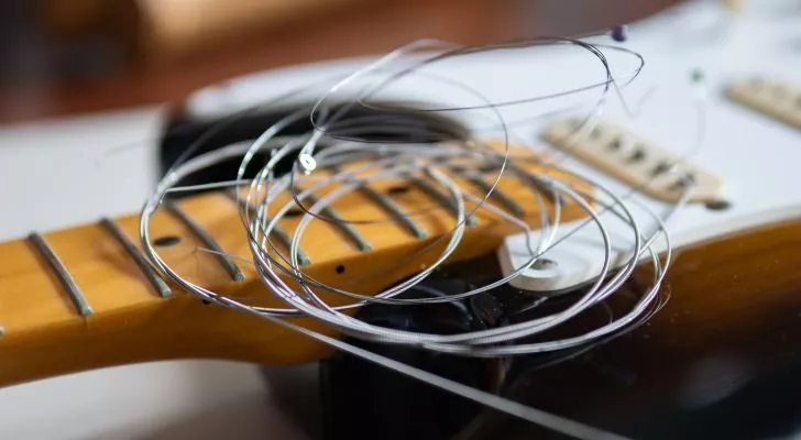 Някои китарни струни лежат върху китара без струни
