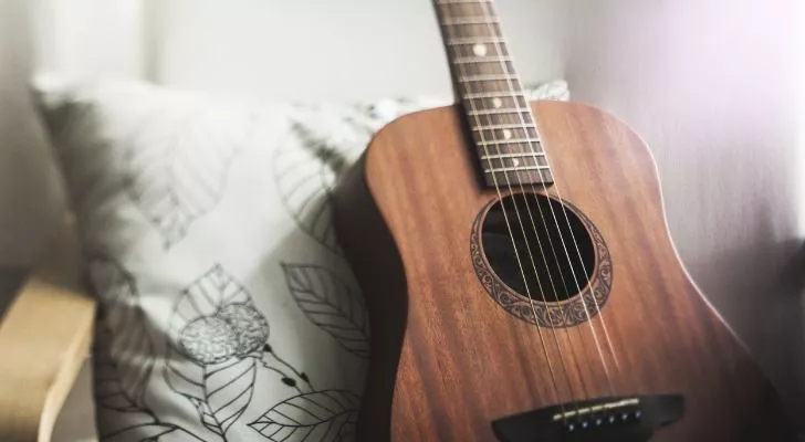 Кафява китара се обляга на възглавница