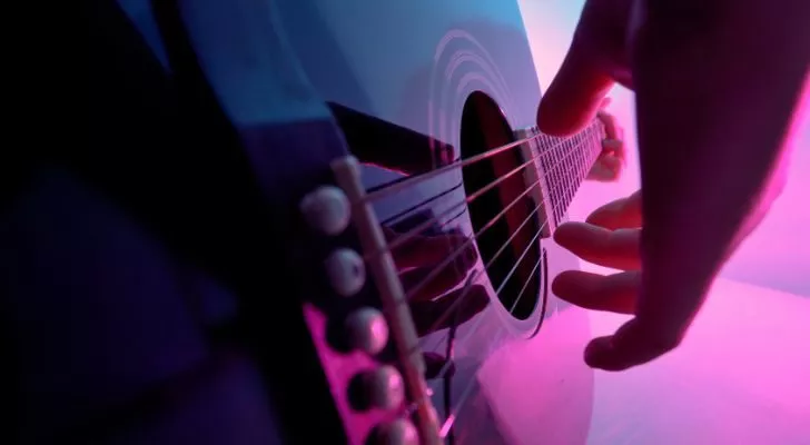 Близък план на ръка, скубяща струни на китара