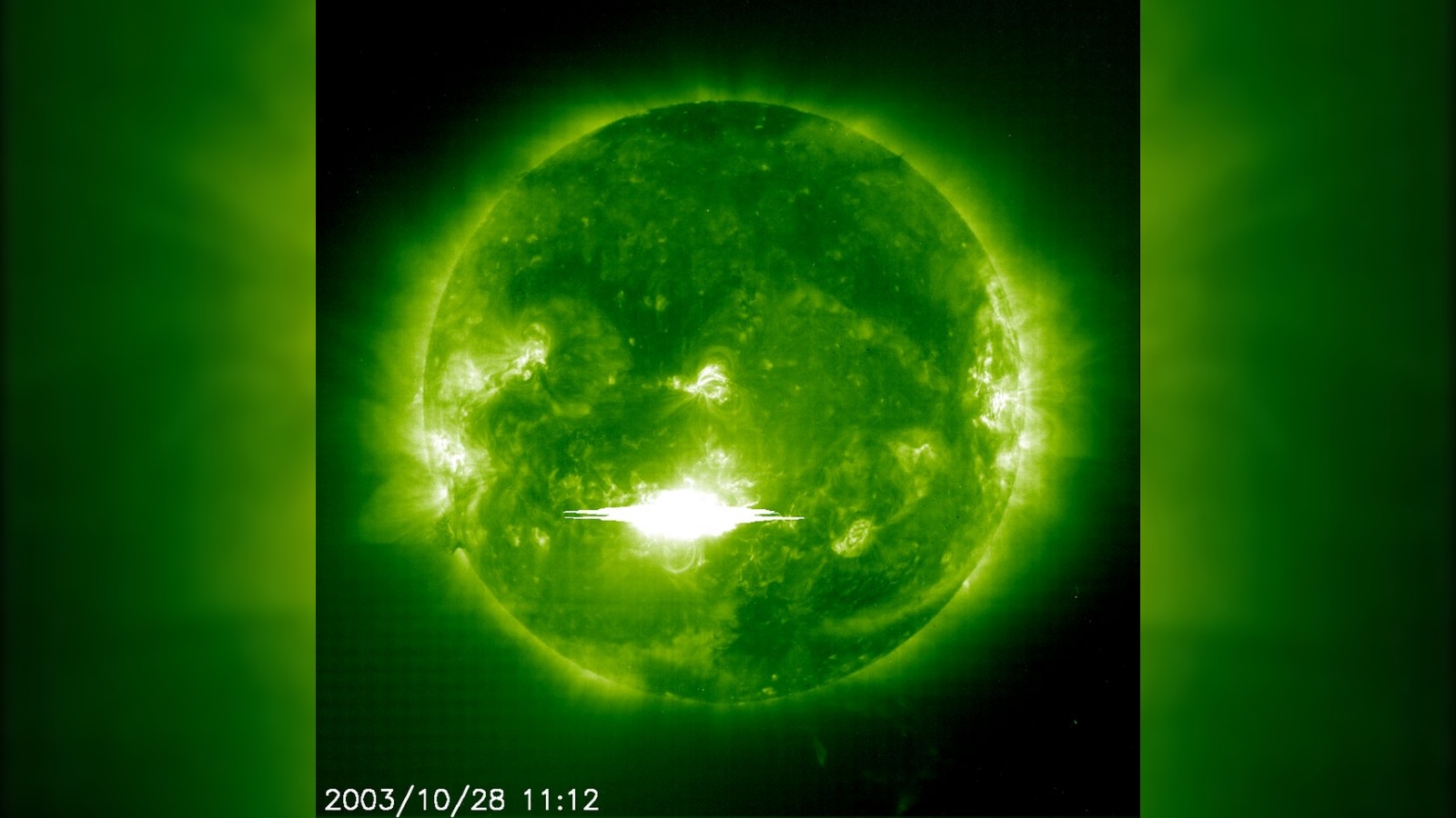 Слънцето, гледано през зелен филтър с масивна светкавица, изригваща от повърхността му