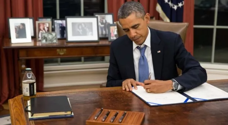 Барак Обама подписва документ в Овалния кабинет