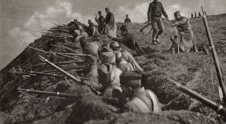 A trench full of soldiers stretches off into the distance