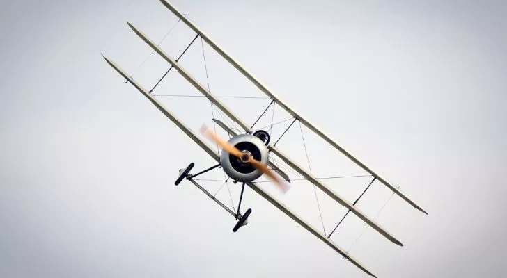 A triplane flies directly forwards while rolling to the side