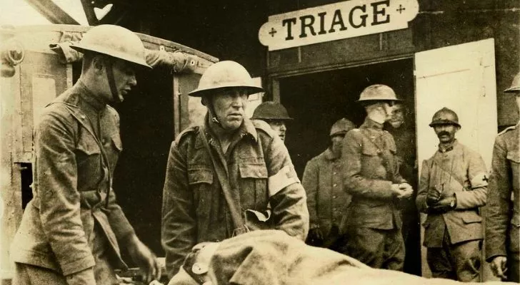 Soldiers with a casualty stand in front of a triage room