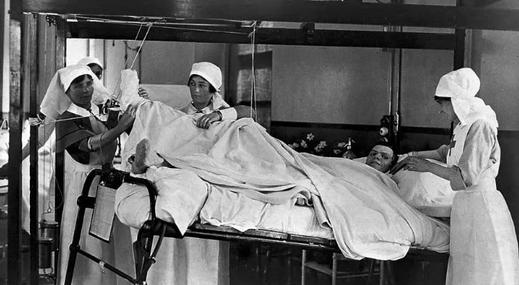Nurses in a hospital tend to a wounded man