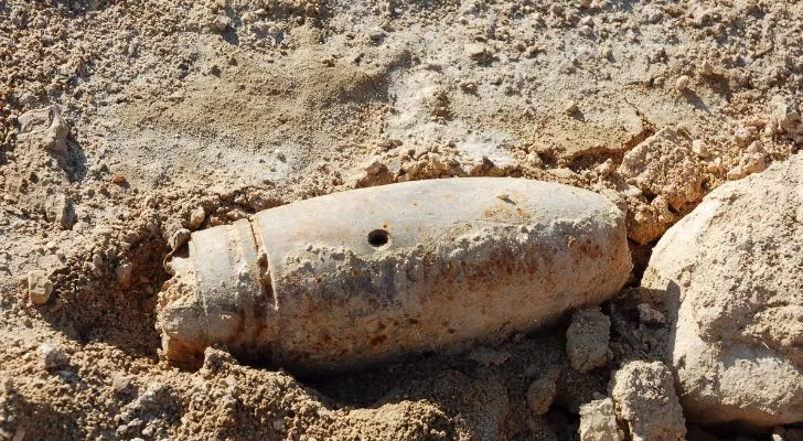 An unexploded shell in the dirt