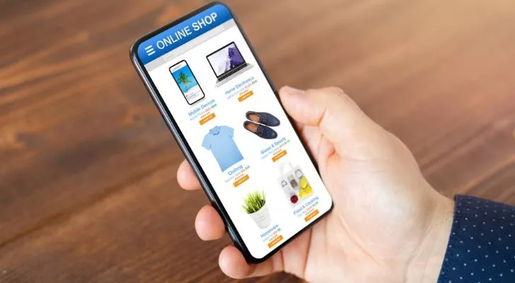 Мъжка ръка държи телефон с отворен онлайн магазин