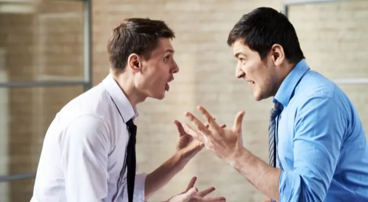Двама мъже с ризи и вратовръзки се карат