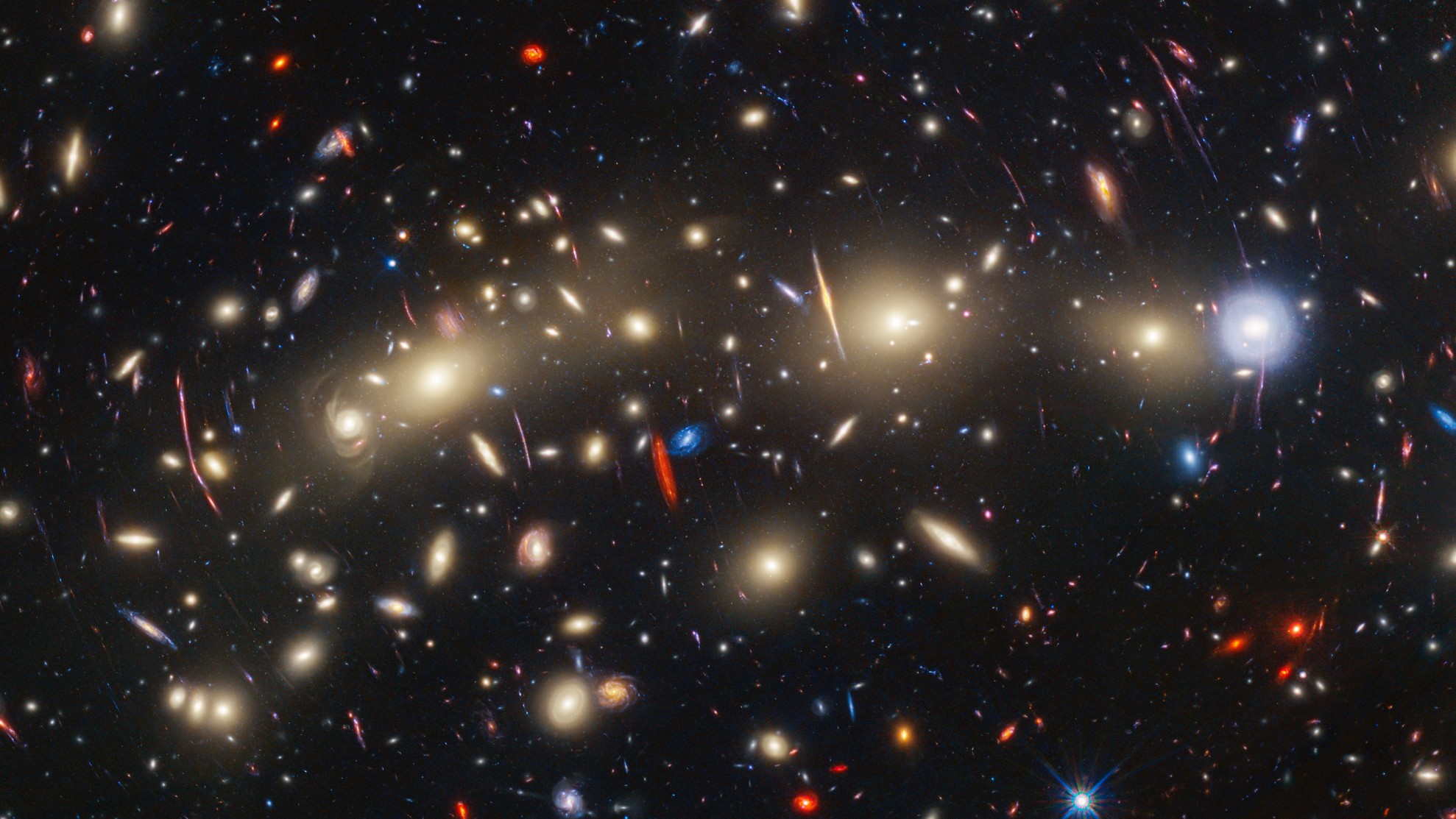 Виждаме масив от мигащи жълти, червени и сини галактики, разпънати в пространството по начин, който напомня коледни светлини