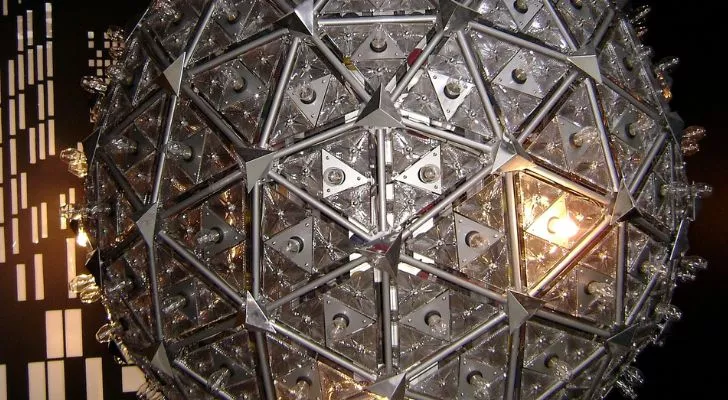 Голяма сребърна топка, конструирана с метална рамка, покрита със светлини