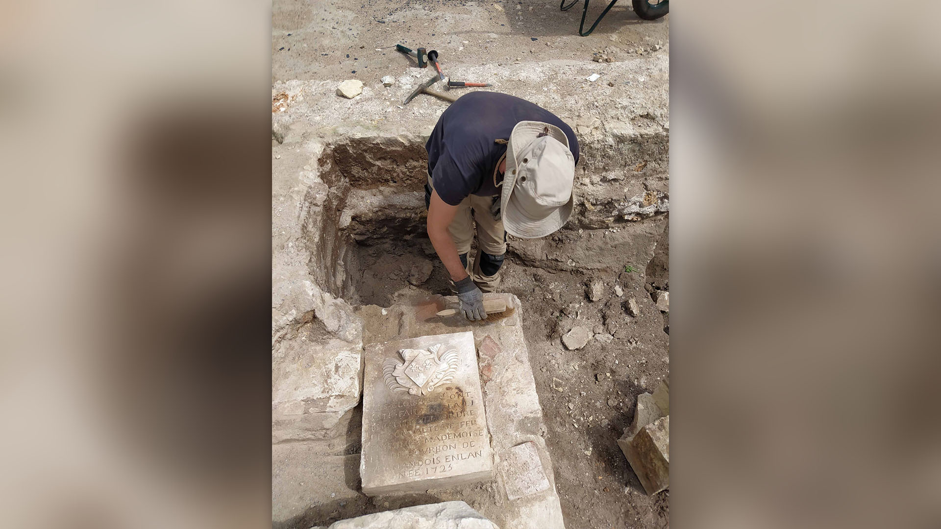 Изследовател открива основен камък в археологически обект.