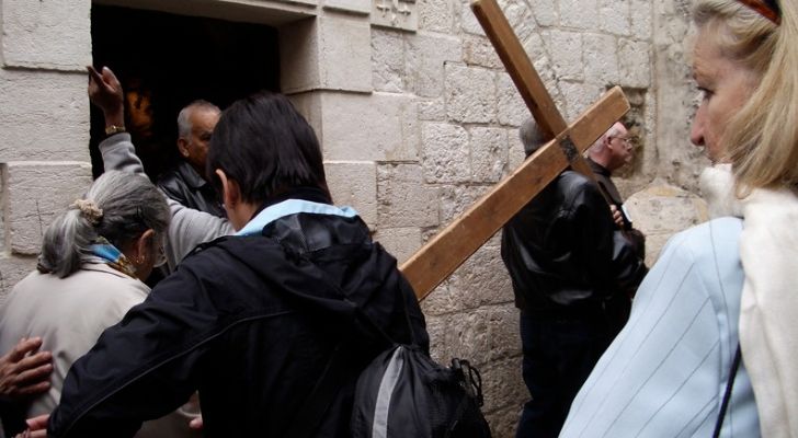 Човек, носещ кръст в Йерусалим като част от процесия