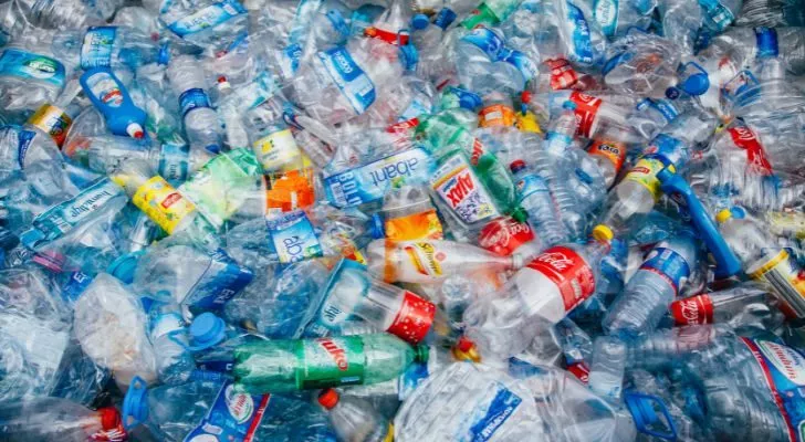 Голяма купчина използвани пластмасови бутилки и контейнери