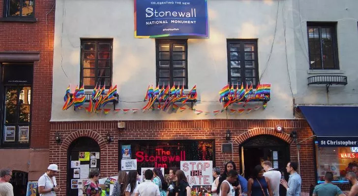 Stonewall Inn с ЛГБТ декорации и тълпа отпред празнуват превръщането му в национален паметник