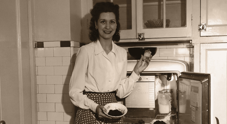 Жена от 50-те години на миналия век стои пред отворен хладилник