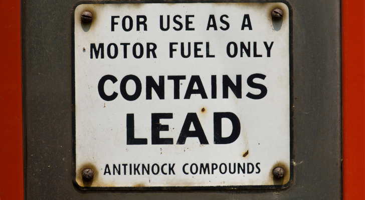 Знак на стара бензинова помпа, който казва "Съдържа олово"